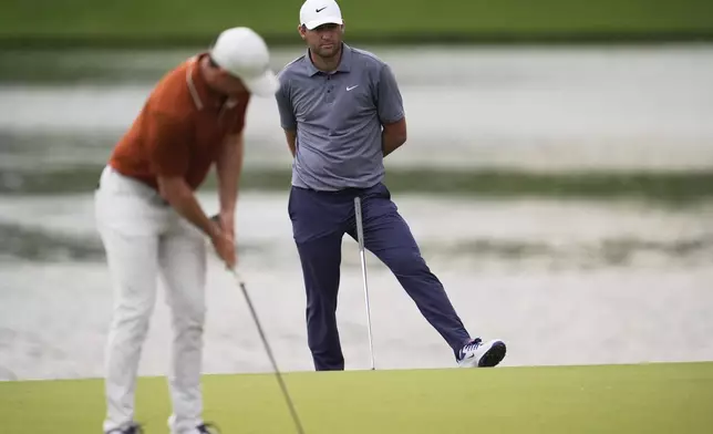 Scottie Scheffler watches as Rory McIlroy, of Northern Ireland, putts on the 14th hole during the second round of the PGA Championship golf tournament at the Quail Hollow Club, Friday, May 16, 2025, in Charlotte, N.C. (AP Photo/George Walker IV)