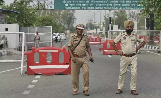 Policemen stand guard on a road leading to the airport in Amritsar, India, after it was closed following India firing missiles into Pakistani-controlled territory, Wednesday, May 7, 2025. (AP Photo/Prabhjot Gill)