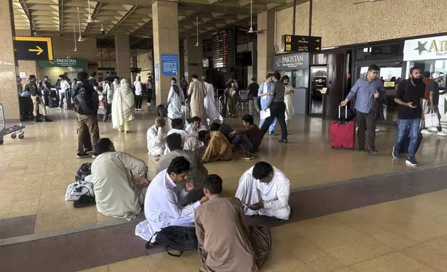 Stranded passengers wait at an arrival area of Jinnah airport after authorities closed the airport due to India's drone attack to Pakistan, in Karachi, Pakistan, Thursday, May 8, 2025. (AP Photo/Mohammad Farooq)