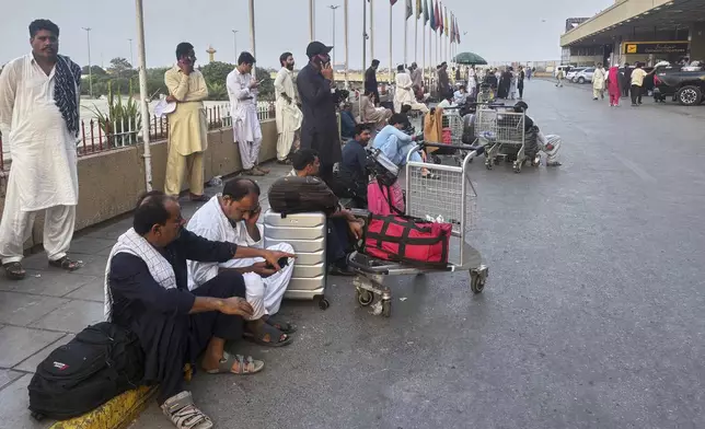 Stranded passengers wait at a arrival area of Jinnah airport, which shutdown following Indian airstrikes in Pakistani areas, in Karachi, Pakistan, Wednesday, May 7, 2025. (AP Photo/Mohammad Farooq)