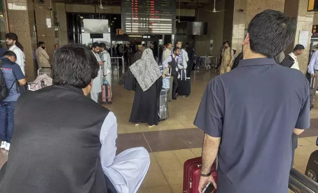 Stranded passengers wait at an arrival area of Jinnah airport after authorities closed the airport due to India's drone attack to Pakistan, in Karachi, Pakistan, Thursday, May 8, 2025. (AP Photo/Mohammad Farooq)