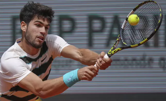 Spain's Carlos Alcaraz returns the ball to Italy's Giulio Zeppieri during their first round match of the French Tennis Open, at the Roland-Garros stadium, in Paris, Monday, May 26, 2025. (AP Photo/Thibault Camus)