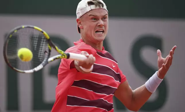 Denmark's Holger Rune returns the ball to Spain's Roberto Bautista Agut during their first round match of the French Tennis Open, at the Roland-Garros stadium, in Paris, Monday, May 26, 2025. (AP Photo/Christophe Ena)