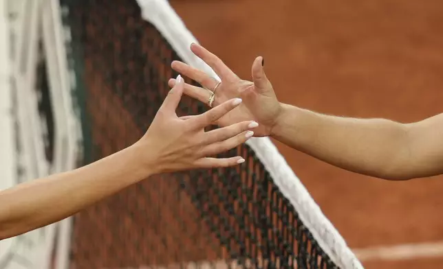 United States' Jessica Pegula, right, reaches for the hand of Romania's Anca Todoni at the end of their first round match of the French Tennis Open at the Roland-Garros stadium in Paris, Tuesday, May 27, 2025. (AP Photo/Aurelien Morissard)