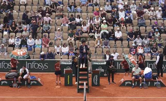 Taylor Fritz of the U.S., left, and Germany's Daniel Altmaier sit during their first round match of the French Tennis Open, at the Roland-Garros stadium, in Paris, Monday, May 26, 2025. (AP Photo/Lindsey Wasson)