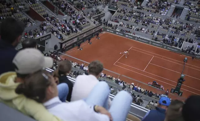 Spectators watch Spain's Paula Badosa playing Japan's Naomi Osaka during their first round match of the French Tennis Open, at the Roland-Garros stadium, in Paris, Monday, May 26, 2025. (AP Photo/Christophe Ena)
