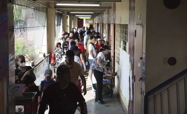 Voters line up to cast their ballots at a polling station in Quezon City, Philippines, Monday, May 12, 2025. (AP Photo/Basilio Sepe)