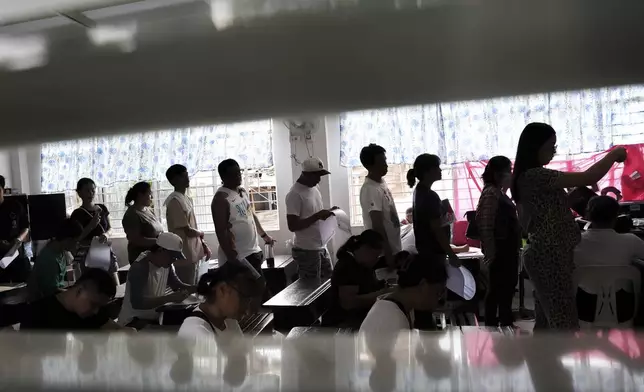 Voters queue as they cast their ballots at a polling station, in Quezon City, Philippines, Monday, May 12, 2025. (AP Photo/Basilio Sepe)