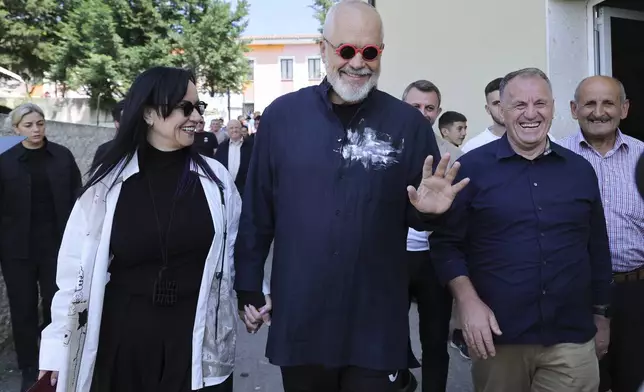 Albania's ruling Socialist party leader Edi Rama, center, and his wife Linda, left, leave a voting station during a general election where Rama is seeking a fourth term as Albania's prime minister in Tirana, Albania Sunday, May 11, 2025. (AP Photo/Vlasov Sulaj)