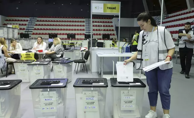 An employee handles the mail-in ballots , as Albania is heading to the polls on Sunday with Socialist Prime Minister Edi Rama seeks a fourth term, in Tirana, Albania, Friday, May 9, 2025. (AP Photo/Vlasov Sulaj)