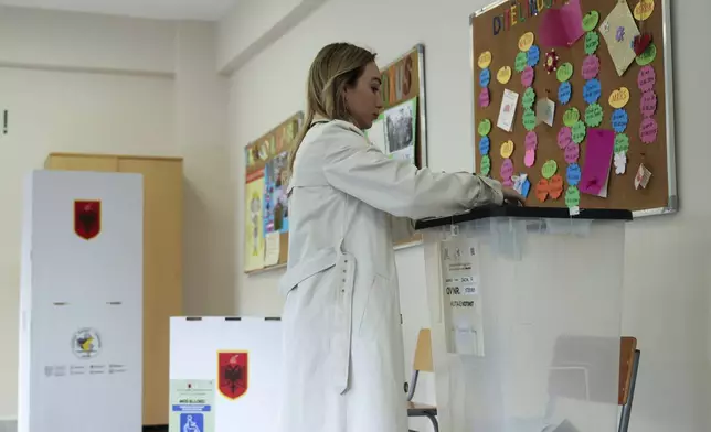 A woman casts her ballot during a general election, as Prime Minister Edi Rama is seeking a fourth term as Albania's prime minisster in Tirana, Sunday, May 11, 2025. (AP Photo/Vlasov Sulaj)