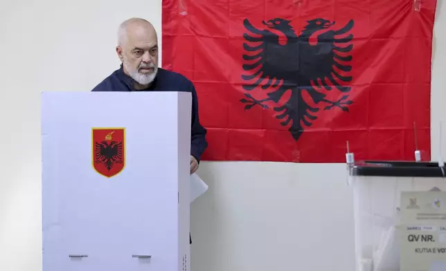 Albania's Socialist party leader Edi Rama stands behind a booth ahead of casting his ballot, during a general election where Rama is seeking a fourth term as Albania's prime minister, in Tirana, Sunday, May 11, 2025. (AP Photo/Vlasov Sulaj)