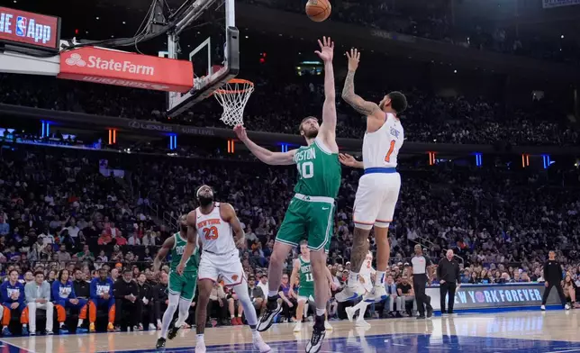 New York Knicks' Cameron Payne, right, shoots over Boston Celtics' Luke Kornet, center, during the first half of Game 3 of an NBA basketball second-round playoff series, Saturday, May 10, 2025, in New York. (AP Photo/Pamela Smith)
