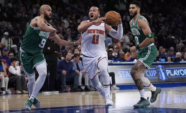 New York Knicks' Jalen Brunson, center, drives to the basket between Boston Celtics' Derrick White, left, and Jayson Tatum, right, during the first half of Game 3 of an NBA basketball second-round playoff series, Saturday, May 10, 2025, in New York. (AP Photo/Pamela Smith)