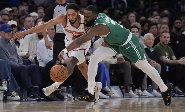 New York Knicks' Cameron Payne, left, and Boston Celtics' Jaylen Brown, right, battle for the ball during the first half of Game 3 of an NBA basketball second-round playoff series, Saturday, May 10, 2025, in New York. (AP Photo/Pamela Smith)