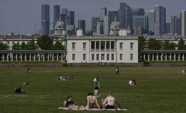 People sunbathe on a sunny day at a park in London, Thursday, May 1, 2025. (AP Photo/Kin Cheung)