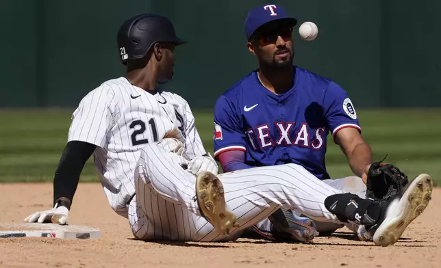 Chicago White Sox's Michael A. Taylor, left, is safe at second base with a double as Texas Rangers second baseman Marcus Semien, right, makes a late tag during the ninth inning of a baseball game Sunday, May 25, 2025, in Chicago. (AP Photo/David Banks)