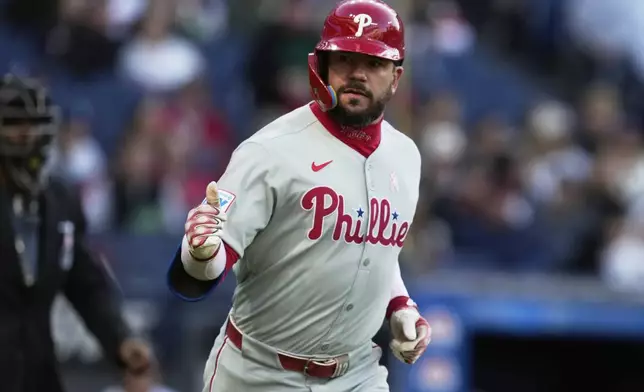 Philadelphia Phillies' Kyle Schwarber gestures to the dugout as he runs toward first base with a home run in the second inning of a baseball game against the Cleveland Guardians in Cleveland, Sunday, May 11, 2025. (AP Photo/Sue Ogrocki)