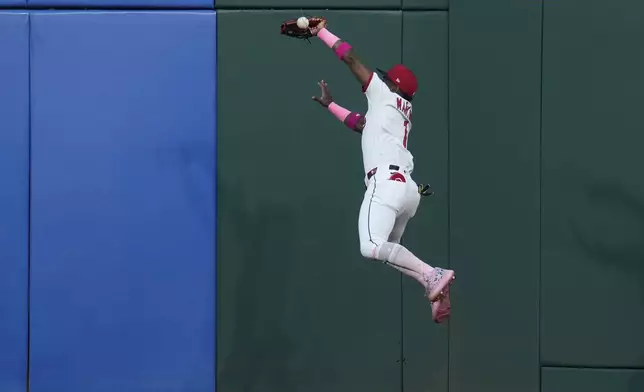 Cleveland Guardians center fielder Angel Martinez (1) jumps for the ball hit for a double by Philadelphia Phillies' J.T. Realmuto in the second inning of a baseball game in Cleveland, Sunday, May 11, 2025. (AP Photo/Sue Ogrocki)