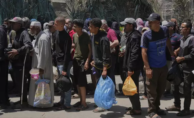Palestinians line up for food distribution in Deir al-Balah, Gaza Strip, Friday, May 30, 2025. (AP Photo/Abdel Kareem Hana)