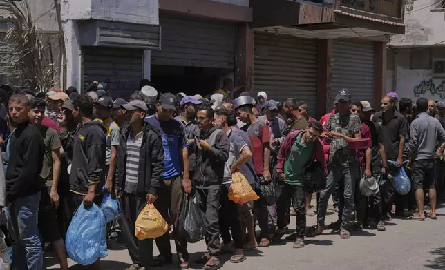 Palestinians line up for food distribution in Deir al-Balah, Gaza Strip, Friday, May 30, 2025. (AP Photo/Abdel Kareem Hana)