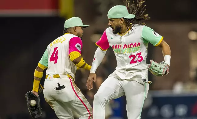 San Diego Padres first baseman Luis Arraez (4) and right fielder Fernando Tatis Jr. (23) celebrate after winning a baseball game against the Pittsburgh Pirates, Friday, May 30, 2025, in San Diego. (AP Photo/Tony Ding)
