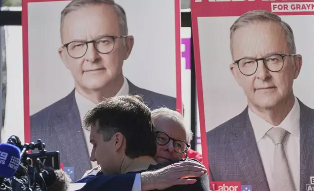 Australian Prime Minister Anthony Albanese embraces his son Nathan as he arrives at a polling booth to vote in his electorate in Sydney, Saturday, May 3, 2025. (AP Photo/Rick Rycroft)