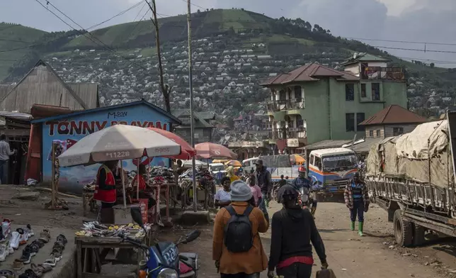People walk through the town near the coltan mining quarry in Rubaya, Democratic Republic of Congo, on Friday, May 9, 2025. (AP Photo/Moses Sawasawa)