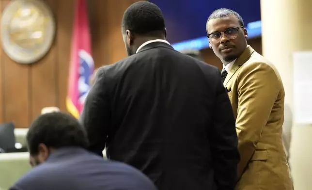 Former Memphis Police Officer Justin Smith Jr., right, one of three former Memphis officers charged with fatally beating Tyre Nichols in 2023, stands in the courtroom with his fellow defendants Tedarrius Bean, center, and Demetrius Haley, left, during break in the trial Wednesday, April 30, 2025, in Memphis, Tenn. (AP Photo/George Walker IV, Pool)