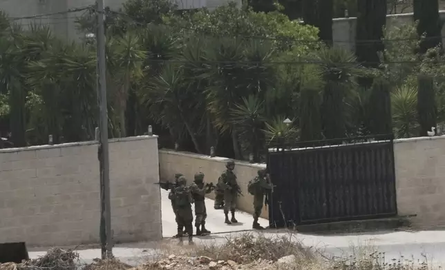 Israeli soldiers search a Palestinian village next to the West Bank settlement of Bruchin, the morning after a Palestinian gunman killed Tzeela Gez, who was on her way to the hospital to give birth, Thursday, May 15, 2025. (AP Photo/Maya Alleruzzo)