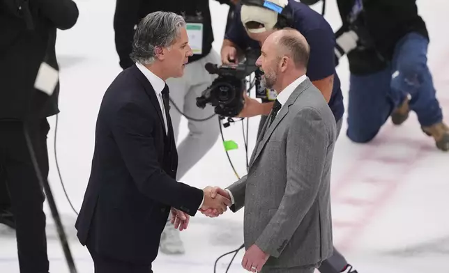 Colorado Avalanche head coach Jared Bednar, left, and Dallas Stars head coach Pete DeBoer, right, greet each other on the ice after their team's Game 7 of a first-round NHL hockey playoff series Saturday, May 3, 2025, in Dallas. (AP Photo/Julio Cortez)