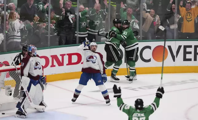 Colorado Avalanche goaltender Mackenzie Blackwood (39) and Samuel Girard, center, look on as the Dallas Stars celebrate a goal scored by Dallas Stars' Mikko Rantanen, rear, in the third period in Game 7 of a first-round NHL hockey playoff series Saturday, May 3, 2025, in Dallas. (AP Photo/Julio Cortez)