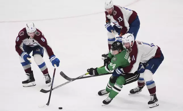 Dallas Stars center Mikael Granlund (64) works for control of the puck against Colorado Avalanche's Cale Makar (8), Valeri Nichushkin (13) and Brock Nelson (11) in the third period in Game 7 of a first-round NHL hockey playoff series Saturday, May 3, 2025, in Dallas. (AP Photo/Julio Cortez)