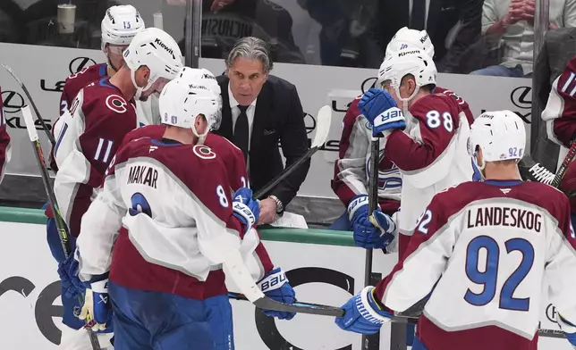 Colorado Avalanche head coach Jared Bednar, center, instructs Cale Makar (8), Gabriel Landeskog (92) and others during a time out in the third period in Game 7 of a first-round NHL hockey playoff series against the Dallas Stars Saturday, May 3, 2025, in Dallas. (AP Photo/Julio Cortez)