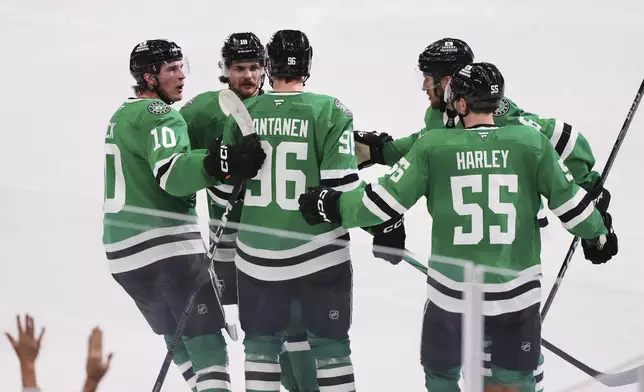 Dallas Stars' Mikko Rantanen (96) celebrates after scoring with Oskar Back (10), Thomas Harley (55) and the rest of the line in the third period in Game 7 of a first-round NHL hockey playoff series against the Colorado Avalanche Saturday, May 3, 2025, in Dallas. (AP Photo/Julio Cortez)
