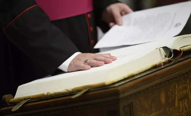 In this image made available on Tuesday, May 6, 2025 by Vatican Media, Vatican Master of Ceremonies Archbishop Diego Giovanni Ravelli takes the oath of secrecy for all those assigned to the conclave during a ceremony in the Pauline Chapel at the Vatican, Monday, May 5, 2025. (Vatican Media via AP)