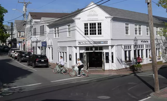 Visitors ride bikes on the street used for a Fourth of July parade in the movie "Jaws," Wednesday, May 14, 2025, in Edgartown, Mass. (AP Photo/Robert F. Bukaty)