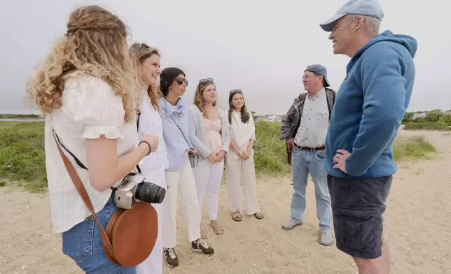 Endurance swimmer Louis Pugh answers questions about his planned swim while chatting with visitors to Martha's Vineyard, Thursday, May 15, 2025, in Edgartown, Mass. (AP Photo/Robert F. Bukaty)