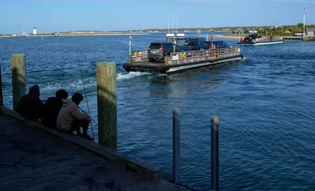 Young fishermen watch the Chappaquiddick ferries, Wednesday, May 14, 2025, in Edgartown, Mass. (AP Photo/Robert F. Bukaty)