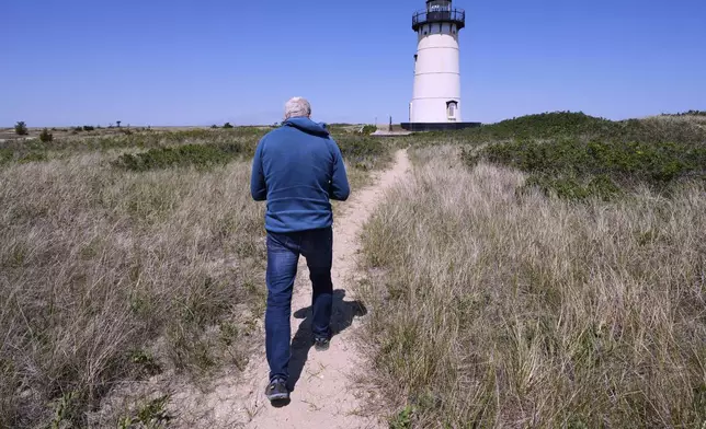 Endurance swimmer Lewis Pugh walks towards the Edgartown lighthouse, which will be the starting point for his 12-day swim around Martha's Vineyard island, Monday, May 12, 2025, in Edgartown, Mass. (AP Photo/Charles Krupa)
