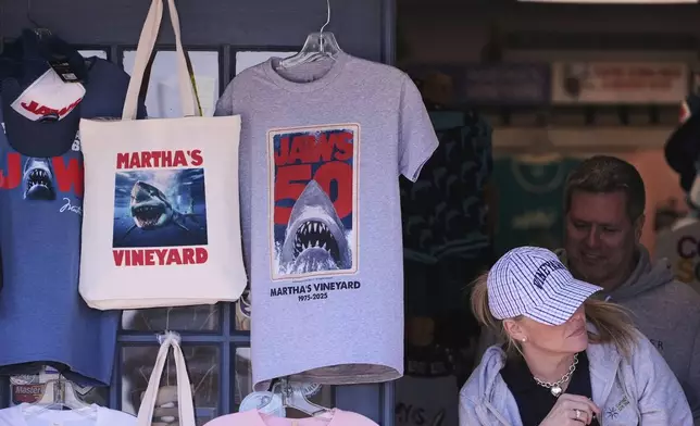 A shopper walks past items featuring the Jaws movie at Neptune's Sea Chest gift shop, Monday, May 12, 2025, in Vineyard Haven, Mass., on Martha's Vineyard Island. (AP Photo/Charles Krupa)