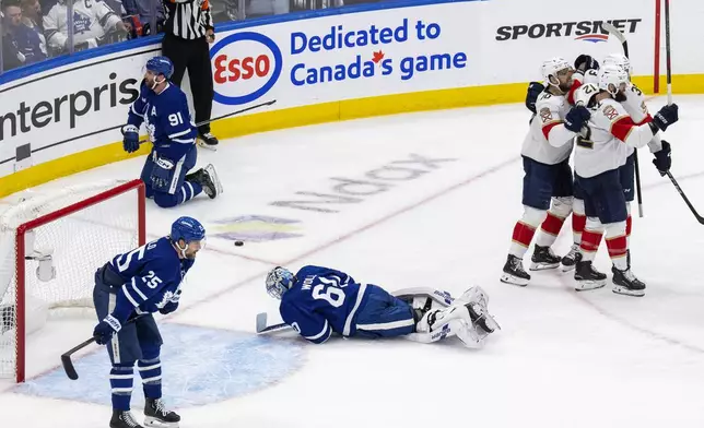 Florida Panthers left wing Jonah Gadjovich (12) celebrates after his goal with teammates as Toronto Maple Leafs goaltender Joseph Woll (60) and others look on during the second period of Game 7 of a second-round NHL hockey playoff series in Toronto, Sunday, May 18, 2025. (Chris Young/The Canadian Press via AP)