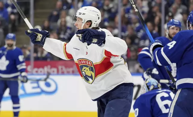 Florida Panthers center Eetu Luostarinen, center, celebrates after scoring against Toronto Maple Leafs goaltender Joseph Woll (60) during the third period of Game 7 of a second-round NHL hockey playoff series in Toronto, Sunday, May 18, 2025. (Frank Gunn/The Canadian Press via AP)