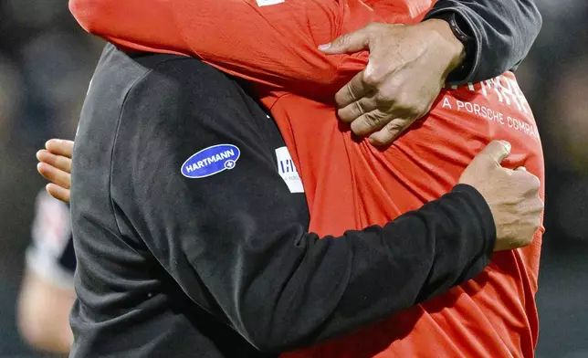 Heidenheim coach Frank Schmidt, left, hugs Heidenheim's Mathias Honsak in a soccer match against Elversberg in the Bundesliga promotion-relegation playoff in Spiesen-Elversberg, Germany, Monday, May 26, 2025. (Uwe Anspach/dpa via AP)