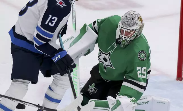Dallas Stars goaltender Jake Oettinger (29) stops a shot from Winnipeg Jets center Gabriel Vilardi (13) in the third period of Game 4 of a second-round NHL hockey playoff series in Dallas, Tuesday, May 13, 2025. (AP Photo/Gareth Patterson)