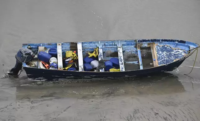 CORRECTS DAY: A boat that capsized sits on the beach Monday, May 5, 2025, in at Torrey Pines State beach in San Diego, Calif. (AP Photo/Denis Poroy)