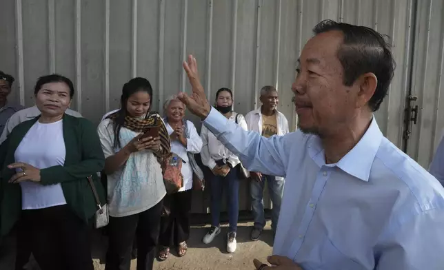 Cambodian prominent opposition politician Rong Chhun, right, waves to his supporters near the Phnom Penh Municipal Court in Phnom Penh, Cambodia, Monday, May 5, 2025. (AP Photo/Heng Sinith)