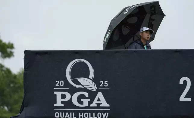 A person walks in the rain over a pedestrian bridge during a practice round for the PGA Championship golf tournament at the Quail Hollow Club, Monday, May 12, 2025, in Charlotte, N.C. (AP Photo/Matt York)