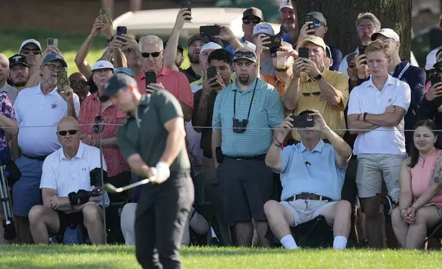 Fans watch as Rory McIlroy, of Northern Ireland, hits on the 11th hole during the first round of the PGA Championship golf tournament at the Quail Hollow Club, Thursday, May 15, 2025, in Charlotte, N.C. (AP Photo/David J. Phillip)