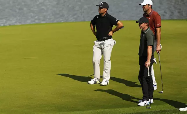 Xander Schauffele, Rory McIlroy, of Northern Ireland, and Scottie Scheffler line up a their putts on the 14th hole during the first round of the PGA Championship golf tournament at the Quail Hollow Club, Thursday, May 15, 2025, in Charlotte, N.C. (AP Photo/David J. Phillip)